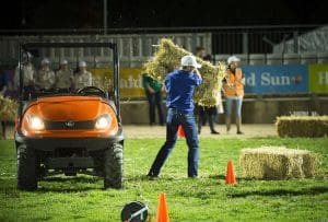 A 2016 Young Farmer Challenge contestant stacks hay.